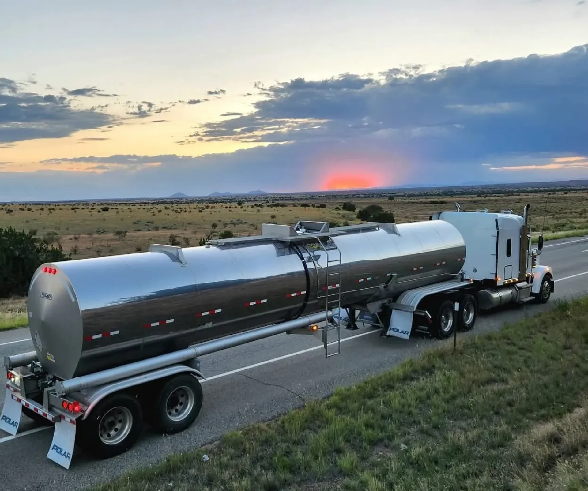 Silver tanker truck with scenic sunset